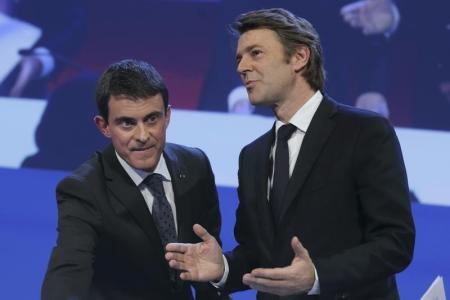 رئيس الوزراء الفرنسي مانويل فالس إلى اليسار وبجواره وزير المالية السابق فرانسوا بارو الذي عين رئيس لرابطة رؤساء البلديات الفرنسية يغادران اجتماعا للرابطة في باريس يوم 27 نوفمببر 2014