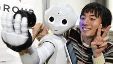 A man poses as humanoid robot Pepper takes a picture at a booth of digital marketing company IMJ Corporation during the Pepper App Challenge 2015 in Tokyo on February 22, 2015. Mobile phone carrier Softbank, which developed the humanoid robot, held the application competiton for Pepper on February 22.   AFP PHOTO / Toru YAMANAKA        (Photo credit should read TORU YAMANAKA/AFP/Getty Images)