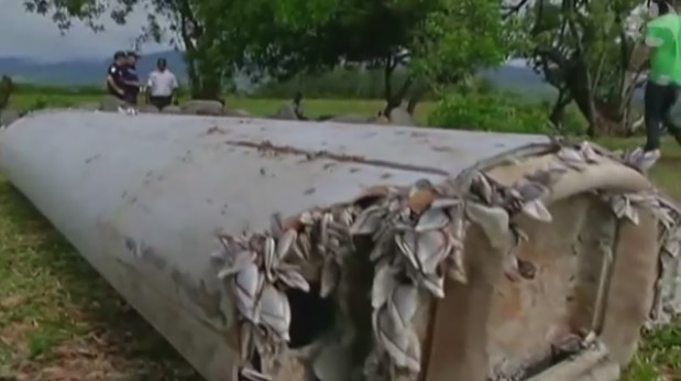 خبراء في الحوادث الجوية يفحصون قطعة من جناح الطائرة يبلغ طولها 2 متر وجدت علي أرض الجزيرة وليس في الماء