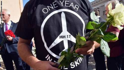 شخص يحمل الزهور لضحايا الطائرة في مسيرة أمام السفارة الهولندية بأوكرانيا يوم 17 يوليو 2015