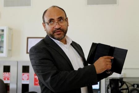 سعود عبد الغني الأستاذ المحاضر بكلية الهندسة في جامعة قطر يحمل قطعة من نموذج لملعب كرة قدم مطبوع بتنية الطباعة ثلاثية الأبعاد في الدوحة يوم 16 يونيو 2016