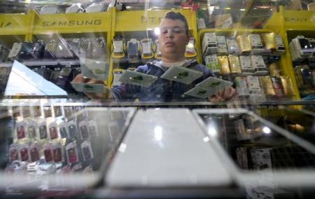 فلسطيني يعرض شرائح للهاتف المحمول تابعة لشركة جوال الفلسطينية في متجر بمدينة غزة يوم الأربعاء 16 نوفمبر 2016