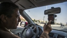 سائق سيارة أوبر يقوم بضيط التطبيق قبل بداية الرحلة