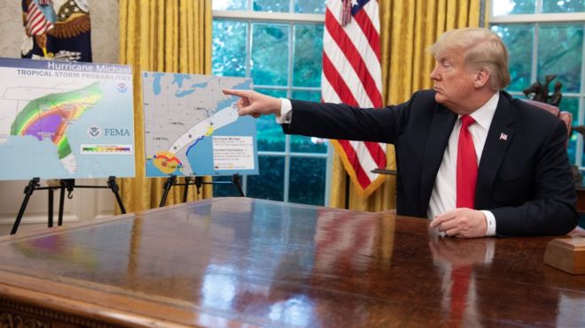 الرئيس الأمريكي ترامب أمام خرائط توضح الأعاصير التي تضرب الولايات الساحلية الشرقية للولايات المتحدة