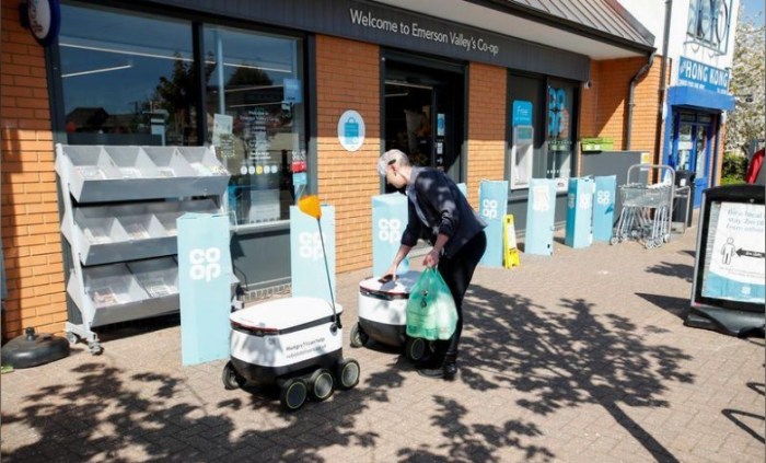 عامل يضع حقيبة داخل روبوت من شركة ستارشيب في ميلتون كينز بإنجلترا يوم 21 ابريل 2020