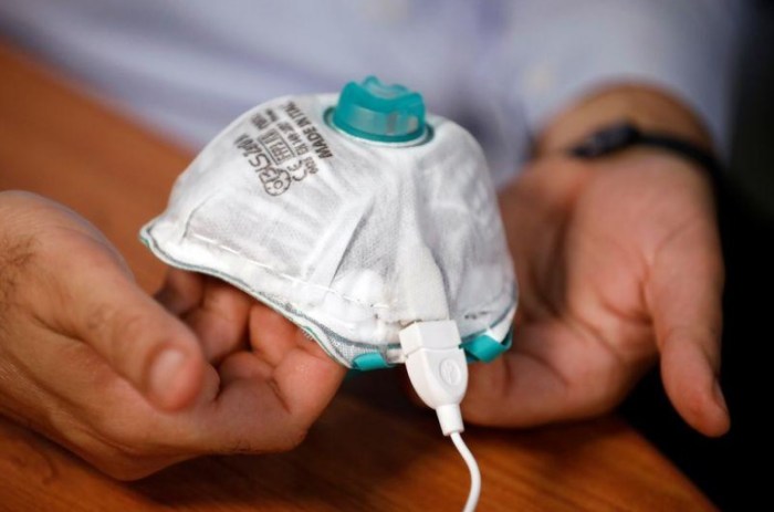 باحث إسرائيلي يعرض كمامة ذاتية التنظيف يمكن أن تقتل كورونا بحرارة من شاحن الموبايل بمختبر في حيفا يوم 10 يونيو 2020