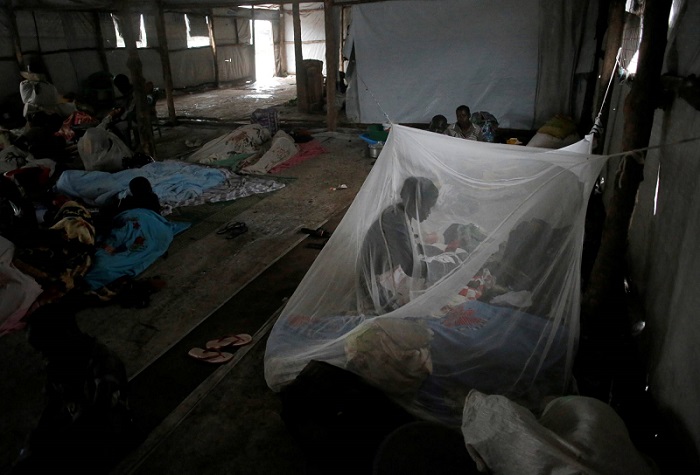 لاجئة من جنوب السودان تعتني بطفلها تحت ناموسية في خيمة مؤقتة في مخيم للاجئين في أوغندا عام 2017