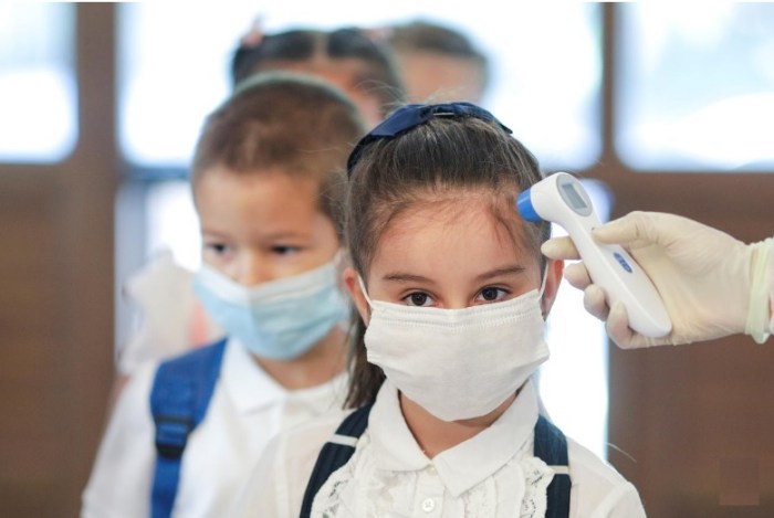أثناء جائحة كورونا ممرضة تقيس درجة حرارة تلاميذ في أحد المدارس بمدينة بوخارست يوم 14 سبتمبر 2020