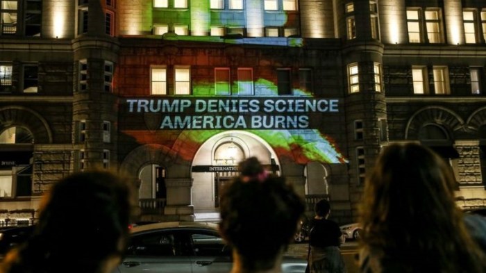 متظاهرون يعترضون على سياسات المناخ للرئيس ترامب ويعرضون رسالتهم على أحد فنادقه