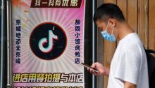 رجل أمام مطعم في بكين يقدم خصما لأي شخص ينشر مقاطع فيديو على تيك توك