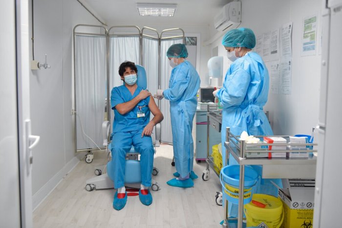 أحد أعضاء الفرق الطبية يتلقي لقاح كورونا في بوخاريست عاصمة رومانيا