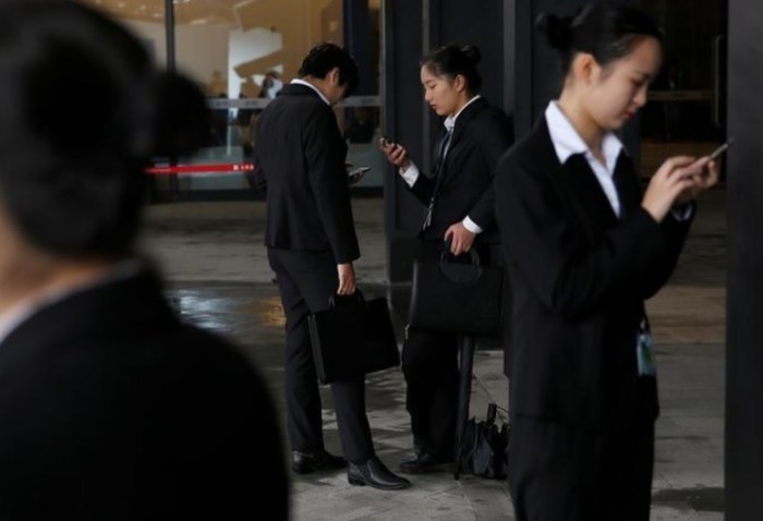 أشخاص يفحصون هواتفهم خلال المؤتمر العالمي السنوي الثالث للإنترنت في مدينة وزهان بمقاطعة زيهجينج، الصين 