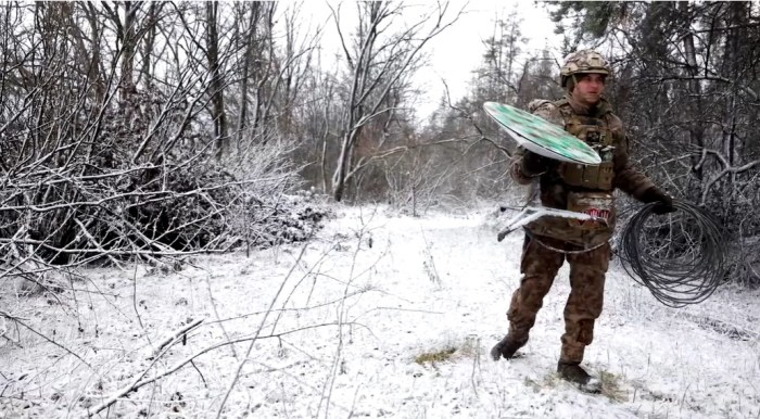 جندي من أوكرانيا يحمل طبق استقبال للاقمار الصناعية لشبكة ستارلينك، تقول سبيس إكس إنها لم تزود أوكرانيا بالتكنولوجيا لاستخدامها لأغراض عسكرية