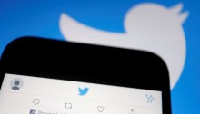 تغريدة إعلانية على تطبيق تويتر على هاتف محمول بالقرب من شعار تويتر، في هذه الصورة التوضيحية التي تم التقاطها في 8 سبتمبر 2022