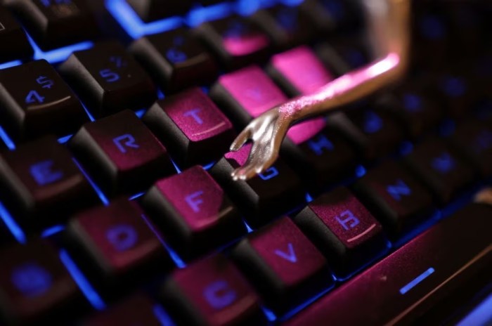 تظهر لوحة المفاتيح واليد المصغرة إشارة الي الذكاء الاصطناعي في هذا الرسم التوضيحي الذي تم تصميمه في 4 مايو 2023