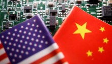 أعلام الصين والولايات المتحدة على لوحة كمبيوتر عليها رقائق أشباه الموصلات، في هذه الصورة التوضيحية المصممة في 17 فبراير 2023