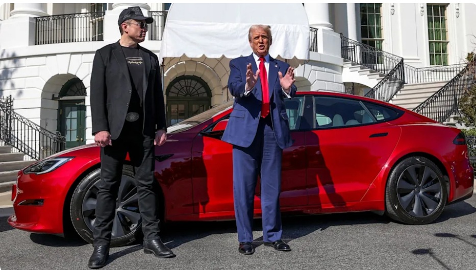 الرئيس دونالد ترامب يتحدث إلى وسائل الإعلام إلى جانب الرئيس التنفيذي لشركة تسلا إيلون ماسك، وفي الخلفية سيارة تسلا، في البيت الأبيض في واشنطن، 11 مارس 2025