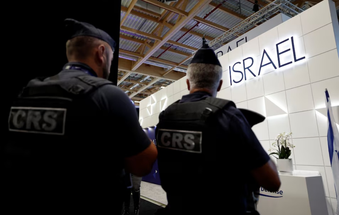 شرطة CRS الفرنسية تمر أمام جناح وزارة الدفاع الإسرائيلية الذي لا يزال مفتوحًا تحت الحراسة، بعد أن أغلقت الجهة المنظمة أربعة أجنحة رئيسية لشركات إسرائيلية في معرض باريس الجوي خلال الدورة 55 لمعرض باريس الجوي في مطار لو بورجيه بالقرب من باريس، فرنسا، في 16 يونيو 2025.