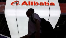 رجل يمر أمام شعار شركة علي بابا المعروض في جناحها خلال معرض سلسلة التوريد الدولية الصيني في بكين، الصين، 16 يوليو 2025
