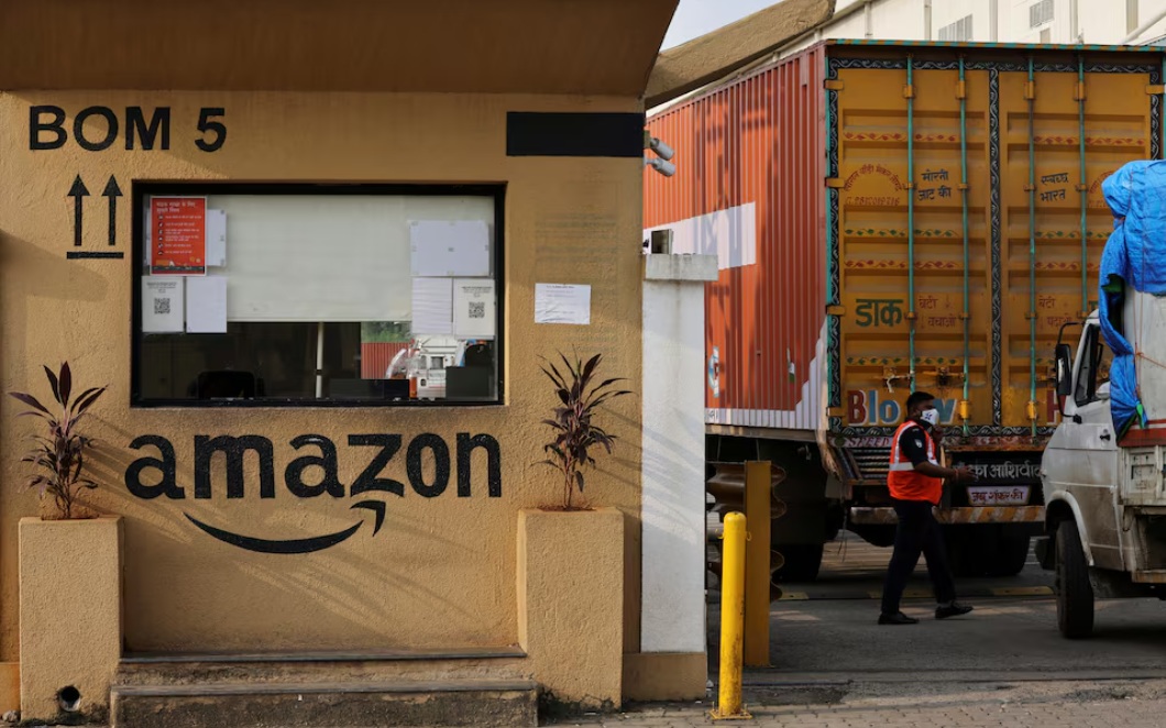 رجل يتفقد الشاحنات قبل دخولها إلى مستودع أمازون في ضواحي مومباي، الهند