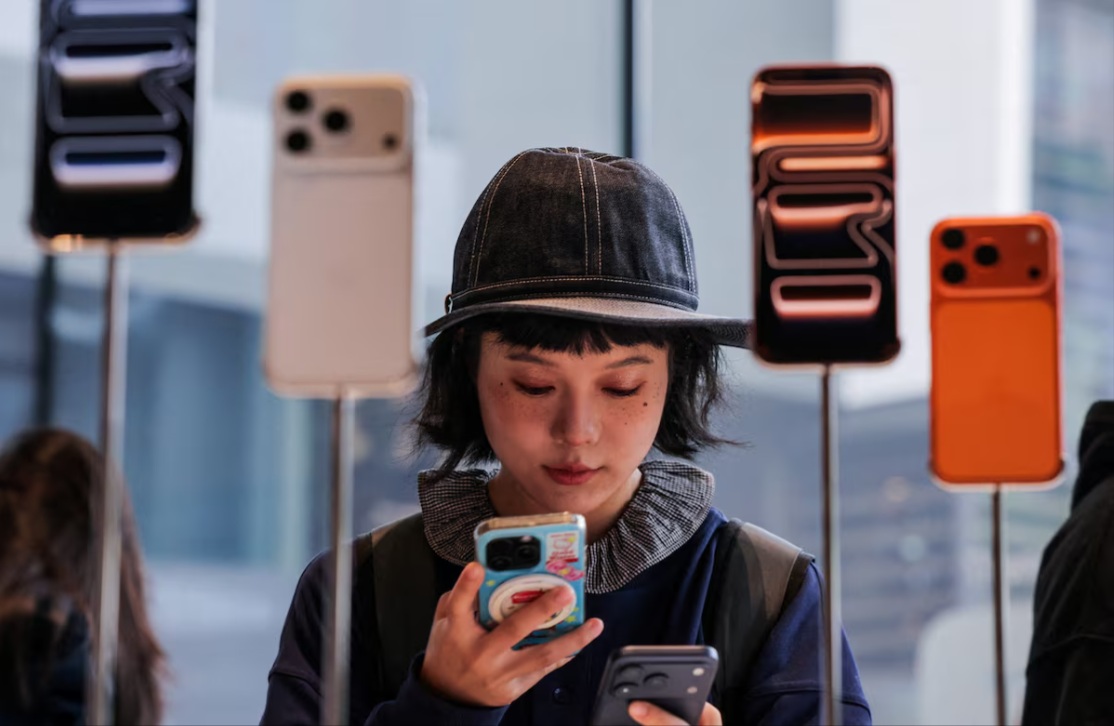 امرأة تستخدم هاتفها الذكي داخل متجر أبل في منطقة سانليتون في بكين مع طرح سلسلة هواتف أيفون 17 الذكية الجديدة للبيع في بكين، الصين، 19 سبتمبر 2025