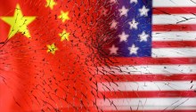 أعلام الولايات المتحدة والصين تظهر من خلال الزجاج المكسور