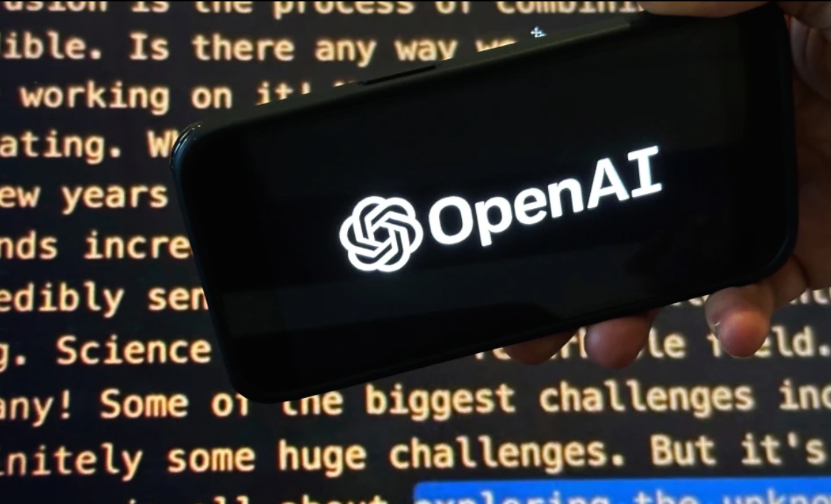 يظهر شعار OpenAI على هاتف محمول أمام شاشة تعرض جزءًا من موقع الشركة الإلكتروني في هذه الصورة التي التقطت في 21 نوفمبر 2023 في نيويورك