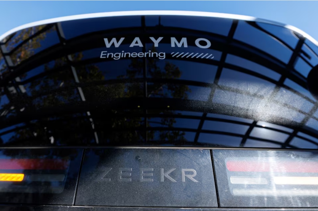نموذج سيارة أجرة روبوتية Waymo Zeekr، تم تطويره بالتعاون مع شركة صناعة السيارات الصينية Geely، يظهر وهو يشحن في محطة شحن عامة أثناء الاختبار قبل بدء توسيع خدمات القيادة الذاتية في سان دييجو، كاليفورنيا، الولايات المتحدة الأمريكية، 19 نوفمبر 2025