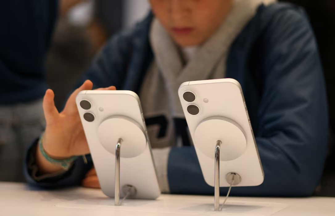  طفل يستخدم هاتف أيفون من شركة أبل معروض في متجر في لندن، بريطانيا، 6 أكتوبر 2024